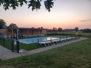 a swimming pool with a gazebo at Les gites de la bouldoire le marronnier in Rignac