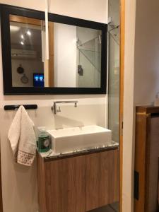 a bathroom with a sink and a mirror at Quarto equipado Centro Balneário Camboriú in Balneário Camboriú