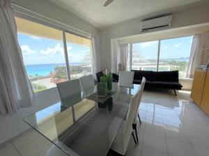 a living room with a glass table and a view of the ocean at Comoda Suite Cancun - BEACH CONDO - 6PX in Cancún