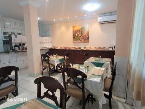 a dining room with tables and chairs in a restaurant at Hotel Graciosa Palace in Palmas