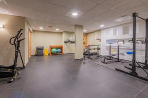 a gym with treadmills and machines in a room at l'Ours Bleu B33 - Ski in Ski out - Happy Rentals in Vallorcine