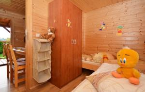Ein großer gelber Teddybär sitzt auf einem Bett in einem Schlafzimmer. in der Unterkunft Domki Bartek in Darłowo + 35 Fotos