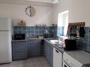 a kitchen with a clock on the wall and a sink at Brignogan maison près de la mer in La Terre du Pont