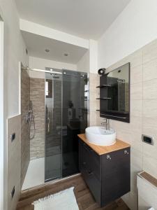 a bathroom with a sink and a glass shower at Casa Chiara in Mandello del Lario +30 photos