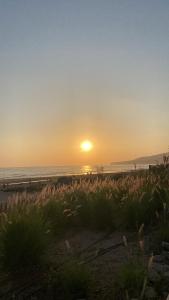 a sunset on the beach with the sun setting at Nova surf house in Tamraght Oufella