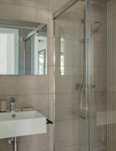 a bathroom with a shower with a sink and a mirror at Villa Sancti Petri, entre el golf y la playa in Novo Sancti Petri