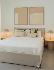 a bedroom with a large white bed with two lamps at Villa Sancti Petri, entre el golf y la playa in Novo Sancti Petri