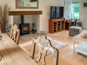 a living room with chairs and a fireplace at The Cottage At West Brinsea Farm in Churchill