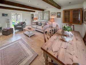 a living room with a wooden table and a couch at The Cottage At West Brinsea Farm in Churchill
