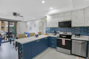 a kitchen with blue cabinets and a stove top oven at 2 Bedroom Oceanview Beachfront Condo Jaco Beach in Jacó