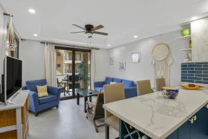 a living room with a table and blue chairs at 2 Bedroom Oceanview Beachfront Condo Jaco Beach in Jacó