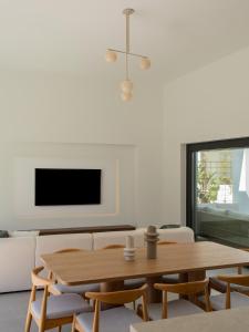 a living room with a table and chairs and a tv at Villa Sancti Petri, entre el golf y la playa in Novo Sancti Petri +55 photos