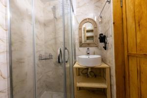 a bathroom with a shower with a sink and a mirror at Mistral Alaçatı Hotel in Çeşme +53 photos