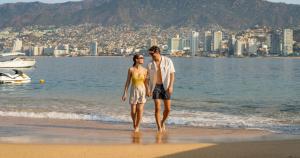 a man and a woman walking on the beach at Park Royal Beach Acapulco - All Inclusive in Acapulco