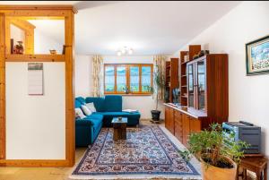 Una sala de estar con un sofá azul y una alfombra. en Ferienwohnung am Fuchsbühl, en Schopfheim