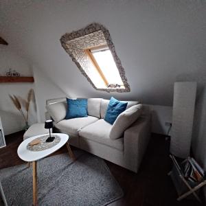 a living room with a couch and a mirror at Schulzis Ferienwohnung in Windeck