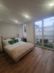 a bedroom with a large bed and a large window at Galeria 3 lustra in Katowice