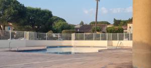 an empty swimming pool in front of a fence at Bastidon l'Arc en ciel in Fréjus