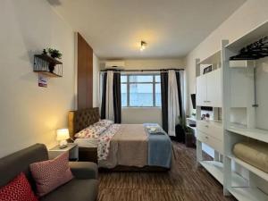 a bedroom with a bed and a couch in a room at Studio compacto no Centro in Florianópolis +12 photos