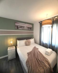 リーズにあるEntire home in Leeds, Free WiFi, 3 Car Parkingの毛布がかけられたベッドのある寝室