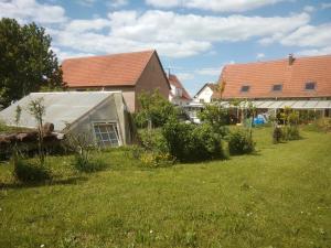 a house with a greenhouse in a yard at Appartement charmant et atypique, wifi, terrasse, jardin in Schleithal +13 photos