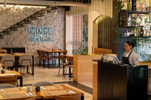 Un uomo in piedi al bancone di un ristorante di Hotel Finlandia a Quito