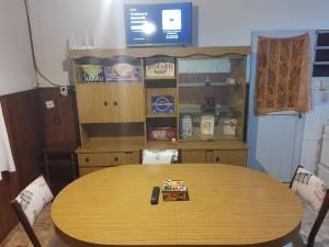 un tavolo in legno con sedie e una TV in camera di Alquiler Corral de Bustos a Corral de Bustos
