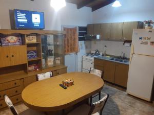 a kitchen with a wooden table and a refrigerator at Alquiler Corral de Bustos in Corral de Bustos