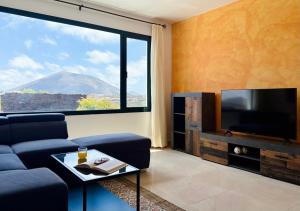 a living room with a blue couch and a large window at Canaryislandshost I Azucena in Tías