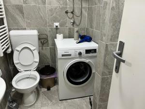 a bathroom with a toilet and a washing machine at Apartment Grey Deluxe in Sarajevo