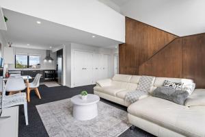 a living room with a white couch and a table at Modern minimalistic apartment,3BR in Auckland