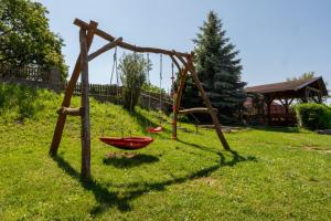 a swing set with a red bowl in the grass at Vinařství a Penzion Maňák in Perná