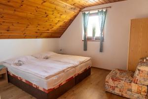 a bedroom with a large bed and a wooden ceiling at Vinařství a Penzion Maňák in Perná