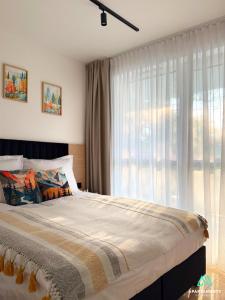 ein Schlafzimmer mit einem Bett mit einem großen Fenster in der Unterkunft APARTAMENTY SZYNDZIELNIA 2 POKOJE & BALKON & PARKING & ROWEROWNIA WORKATION Home OFFICE - NOWA NAJLEPSZA BAZA WYPADOWA W BESKIDY in Bielsko-Biała
