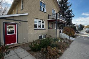 a house with a red door on a street at Main Street Suites Nanton in Nanton