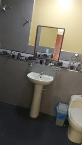a bathroom with a sink and a toilet and a mirror at Hotel Samay Wasi in Tacna