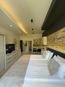 萨拉热窝Boulevard Apartments的一间有两张床和一堵砖墙的大卧室