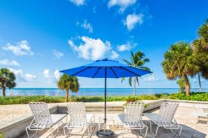 a group of chairs and an umbrella on the beach at Atlantic Parrot in Key West