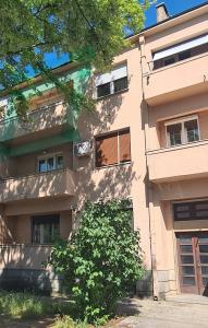 an apartment building with a tree in front of it at CityHeart Apartment in Nikšić