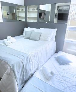 Una cama grande con sábanas blancas y toallas. en Estudio Executivo com Wi-Fi Cozinha e Metro Centro SP, en São Paulo 17 fotos más