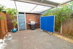 an outdoor patio with a blue door and a table at Bylund Cottage in Albany +62 photos