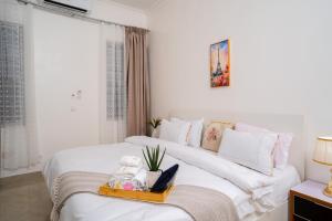 a white room with two beds and a window at 3 Bedroom Luxury Stay in Accra-The Kwaba Villa in Tema