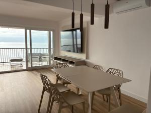 a dining room with a table and chairs and a balcony at Le bateau immobile in Salou