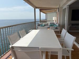 a white table and chairs on a balcony with the ocean at Le bateau immobile in Salou