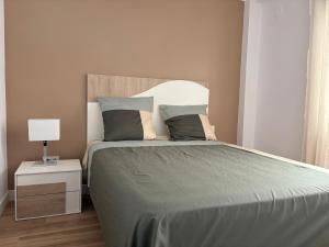 a bedroom with a bed and a night stand with a lamp at Le bateau immobile in Salou