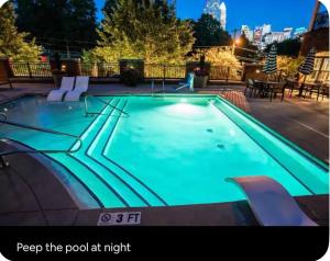 a swimming pool at night with a city in the background at Uptown Charlotte Modern Stay 2BR in Charlotte