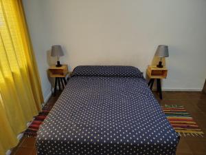 a bed sitting in a room with two night stands at Departamento Plaza España in San Rafael