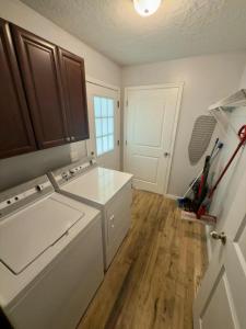Una cocina con fregadero blanco y suelos de madera. en Charming Townhouse Near Lake, en Guntersville