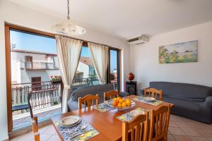 a dining room with a table and chairs and a couch at Luxury Domus Apartment in SantʼAgata di Militello