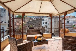 a patio with a table and chairs and an umbrella at Luxury Domus Apartment in SantʼAgata di Militello